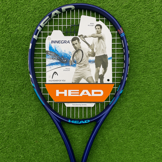 Blue tennis racket with a HEAD label on a green textured background